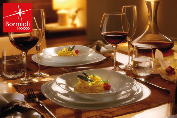 view of a coastal Mediterranean village on a hillside, with small boats in the water.