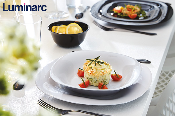 view of a coastal Mediterranean village on a hillside, with small boats in the water.